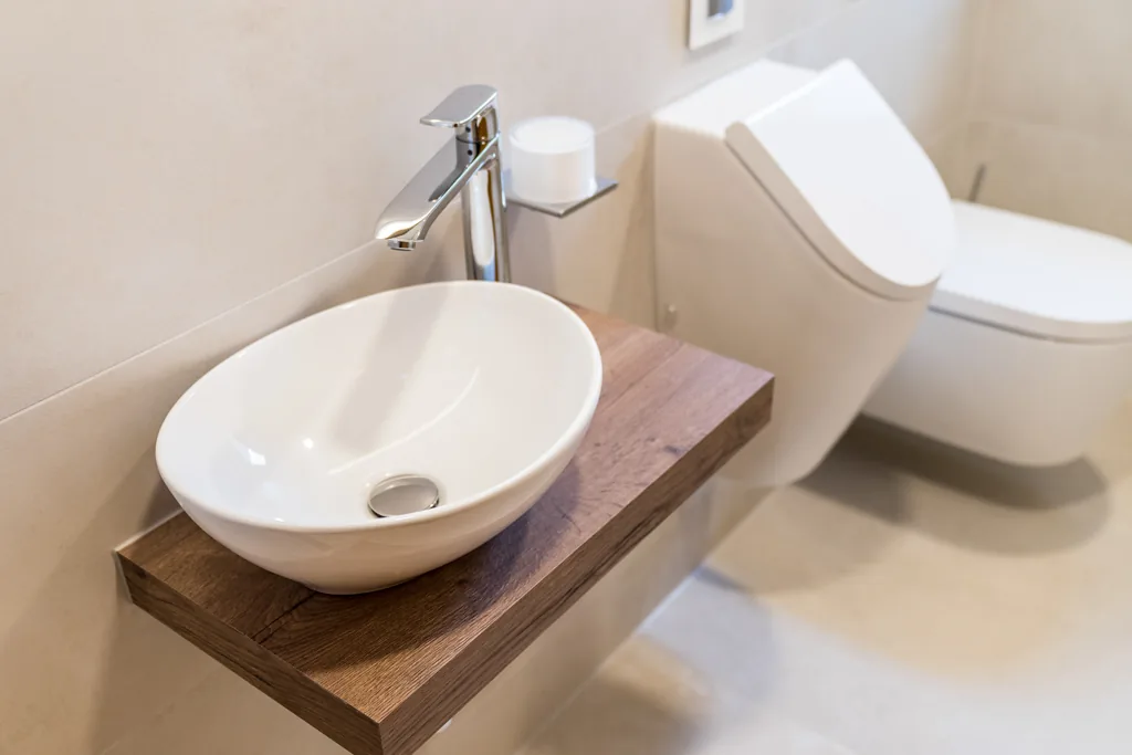 Aufsatzbecken auf einer massiven Holzplatte im Gäste-WC